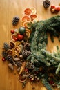 Fir branches, dried pieces of fruit and cones lie on the floor for a Christmas wreath