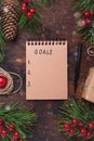 Fir branches, gifts and an notebook on a wooden background. New goals. Christmas background. Top view, copy space Royalty Free Stock Photo