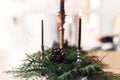 Fir branches with pine cones and vintage candlestick with burning black candles on wooden table. Stylish rustic christmas Royalty Free Stock Photo