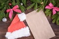 Fir branches, pink ribbon bow, Christmas cap, envelope and christmas balls. New Year background Royalty Free Stock Photo