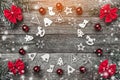 Fir branches with red bows, and xmas handmade toys and balls, creating a circle on a wooden gray background, with space for text