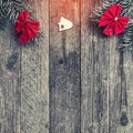 Fir branches with red bows, and xmas handmade toys on wooden gray background, with space for text