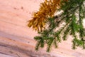 Fir branches with tinsel on a light wooden background.Christmas card.