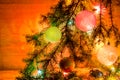 Fir branches with toys, glass balls, tinsel on a light wooden background.Christmas card