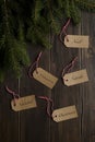 Fir branches on a wooden background, labels with Christmas written in Italian, English, French, Spanish and German. Christmas,