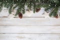 fir leaves and pine cones decorating rustic elements on white wood table with snowflake. Royalty Free Stock Photo