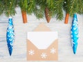 Fir tree branch with cinnamon, cones, snowflakes, craft envelope and blue toys on wooden background Royalty Free Stock Photo