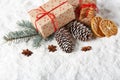 Fir tree branch, cones, gingerbread cookies and gift boxes on a winter snow background with copy space. Royalty Free Stock Photo