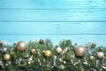 Fir tree branches with Christmas decoration on light blue wooden background. Space for text Royalty Free Stock Photo