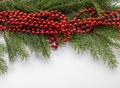 Fir tree branches with Christmas red garland beads decoration on wooden rustic background close-up with copyspace Royalty Free Stock Photo