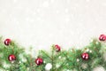 Fir tree branches decorated with red christmas balls as border on a rustic holiday background frame with snow copy space Royalty Free Stock Photo