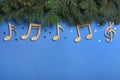 Fir tree branches with wooden music notes and space for text on blue background, flat lay. Christmas celebration Royalty Free Stock Photo