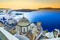 Fira, Santorini, with white village, cobbled paths, greek orthodox blue church and sunset over caldera. Cyclades, Greece Royalty Free Stock Photo