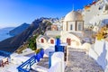 Fira, Santorini, with white village, cobbled paths, greek orthodox blue church and sunset over caldera. Cyclades, Greece Royalty Free Stock Photo