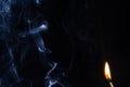 Fire with an abstract figure from blue smoke on a dark background with a place for text, fantasy,fiction, mysticism, magic