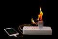 On fire Adapter smart phone charger at plug in power outlet