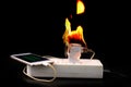 On fire Adapter smart phone charger at plug in power outlet