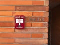 alarm bell and emergency door exit on brick wall Royalty Free Stock Photo
