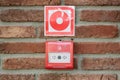 Fire alarm button in emergency system over a wall. Fire alert. Royalty Free Stock Photo