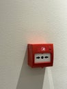 Fire alarm button on white wall with sunlight shadow, suitable as background Royalty Free Stock Photo
