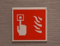 Fire alarm call point symbol on red backdrop with hand Royalty Free Stock Photo