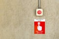 Fire alarm call point service sign label with red color push button switch on cement wall Royalty Free Stock Photo