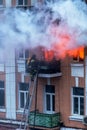 A fire in an apartment building. Strong bright light and clubs, smoke clouds window of their burning house. Firefighters