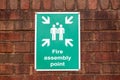 a fire assembly point sign on a brick wall Royalty Free Stock Photo