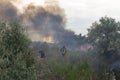 A fire brigade on a fire engine extinguishes a forest fire. Inscriptions on the car in Russian - fire truck and Odessa. 2019. 06.