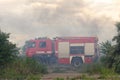 A fire brigade on a fire engine extinguishes a forest fire. Inscriptions on the car in Russian - fire truck and Odessa. 2019. 06.