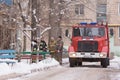 Fire Brigade are at the entrance of an apartment building, standing next to a fire service vehicle