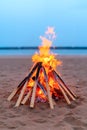 A bonfire on the beach with a blue sky in the background Royalty Free Stock Photo