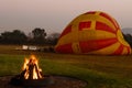 A fire burns in the early morning before a hot air balloon flight.