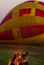 A fire burns in the early morning before a hot air balloon flight.