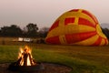 A fire burns in the early morning before a hot air balloon flight.