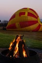 A fire burns in the early morning before a hot air balloon flight.