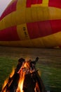 A fire burns in the early morning before a hot air balloon flight.