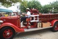 A fire chief drives a antique fire truck