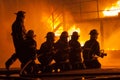 Fire chief and firefighters in front of a burning structure during firefighting exercise