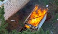 Fire coils over a burnt building. A pile of coals at the site of a burnt shed. Bright flames, flying ashes of a burning wooden Royalty Free Stock Photo