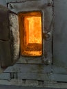 Fire in the combustion chamber of a coal-fired stoker boiler visible through the window Royalty Free Stock Photo
