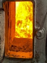 Fire in the combustion chamber of a coal-fired stoker boiler visible through the window Royalty Free Stock Photo