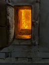 Fire in the combustion chamber of a coal-fired stoker boiler visible through the window Royalty Free Stock Photo