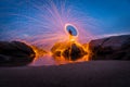 Fire dancer swing fire dancing show on the beach with dark clouds, twilight sky background. Royalty Free Stock Photo