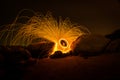 Fire dancer swing fire dancing show on the beach with dark clouds, twilight sky background. Royalty Free Stock Photo