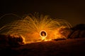 Fire dancer swing fire dancing show on the beach with dark clouds, twilight sky background. Royalty Free Stock Photo