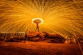 Fire dancer swing fire dancing show on the beach with dark clouds, twilight sky background. Royalty Free Stock Photo