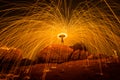 Fire dancer swing fire dancing show on the beach with dark clouds, twilight sky background. Royalty Free Stock Photo