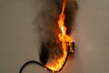 On fire electric wire plug Receptacle on the concrete wall exposed concrete backgroun Royalty Free Stock Photo