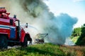 fire engine on the highway extinguishes a burning car after an accident Royalty Free Stock Photo